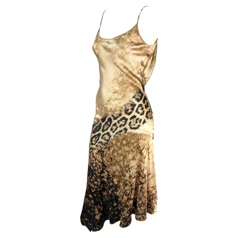 Presenting a stunning beige silk Roberto Cavalli slip dress. From the early 2000s, this gorgeous dress is covered in a tan abstract and leopard print. The dress features a scoop neckline, spaghetti straps, a flared hem, and a draped accent at the back. This sexy is constructed of luxurious silk that perfectly and gently reflects light. Approximate measurements: Size - S Bust: 24-26" Waist: 24" Hips: 28-30" Shoulder to hem: 50" 100% Silk Vintage Designer Dresses, 2000s Dresses, Vintage Roberto Cavalli, Animal Print Mini Dress, Vintage Dress Design, Roberto Cavalli Dress, Cavalli Dress, Slip Midi Dress, Leopard Print Maxi Dress