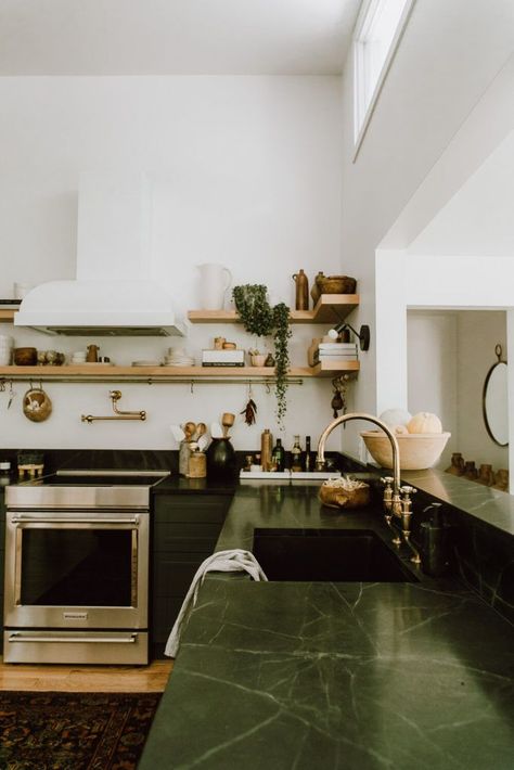 Kitchen with open shelves and dark green countertops