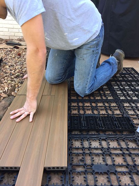 A person snapping in deck boards over a concrete patio. Poured Concrete Patio, Diy Concrete Patio, Pavers Diy, Concrete Patio Makeover, Backyard Covered Patios, Easy Patio, Laying Decking, Deck Flooring, Cement Patio