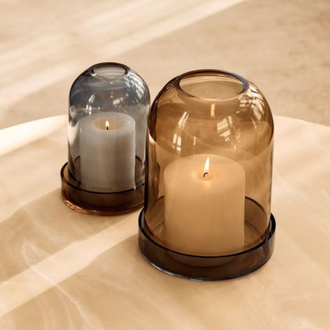 Blown-glass hurricane candle holders are captivating when illuminated. Designed to fit over a pillar candle, the cloche sits over a glass plate for an elegant, two-tone display. When lit, the opening at the top of the cloche draws the smoke upward. CB2 exclusive.  -Blown glass -Wipe with a soft cloth Zumel Round Two-Tone Glass Hurricane Candle Holder Small Brown Glass Candle Holder, Cloche Candles, Candle Holder Aesthetic, Tv Nook, Pillar Candle Decor, House Aesthetics, Round Candle Holder, Candle Vessel, Glass Tealight Candle Holders