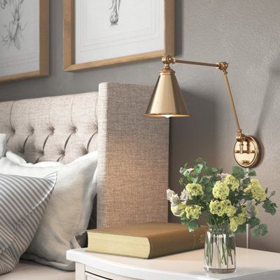 This 1-light wall sconce brings convenient light and classic style to any corner. It's made from metal with a neutral finish, and it has a cone-shaped steel shade for a vintage-inspired look. This sconce features a circular backplate with a slim linear arm that bends and turns to direct light exactly where you want it. The shade holds one standard bulb (sold separately). Whether you place this fixture in your entryway, hallway, or bedroom, it's sure to brighten your space. Finish: Gold | Three P Wall Reading Lights Bedroom, Wall Mount Bedside Lamp, Reading Lights Bedside, Headboard With Sconces, Bedside Lighting Wall Mounted, Bedside Sconces Wall Mount, Bedroom Wall Sconces Bedside Lighting, Bedside Lighting Ideas, Bedroom Sconces Bedside