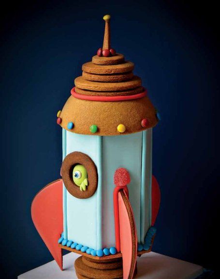 An alien awaits lift-off in Catherine Beddall's adorable riff on the gingerbread house theme. The sweet rocket is one of 16 projects in "The Magic of Gingerbread" (Peter Pauper Press, 2016). Photo courtesy of Catherine Beddall Rocket Ship Cakes, Space Cakes, Homemade Gingerbread House, Rocket Cake, Gingerbread Creations, Rocket Party, Galaxy Party, Cocktail Cake, Gingerbread House Designs