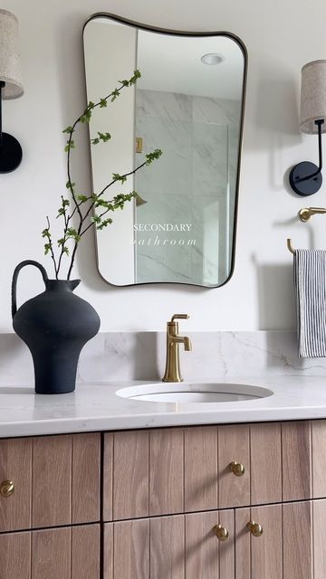 Brooke Talsma on Instagram: "Between the vertical detail on the cabinetry, the two-toned floor tile, the curved quartz backsplash and the mirror/sconce selection… there’s not an element that wasn’t thought about when designing this Secondary Bathroom 🤍
.
Design: @brookemtinteriors 
Build: @klostermanbuild" Secondary Bathroom, Mirror Sconces, Quartz Backsplash, Floor Tile, The Mirror, Backsplash, Bathroom Design, Tile Floor, Tile