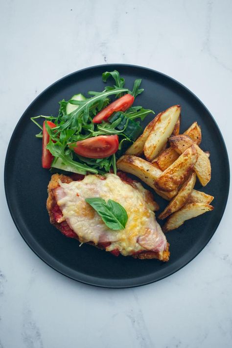 Chicken Parmigiana, or Chicken Parma as it’s best known in Australia, is a delicious chicken schnitzel dish topped with ham, cheese and tomato sauce. Chicken Parmagania, Baked Chips Recipe, Chicken Schnitzel Recipe, Chicken Parma, Oven Baked Chips, Cheese And Tomato, Chicken Ham, Chicken Schnitzel, Chicken Parmigiana