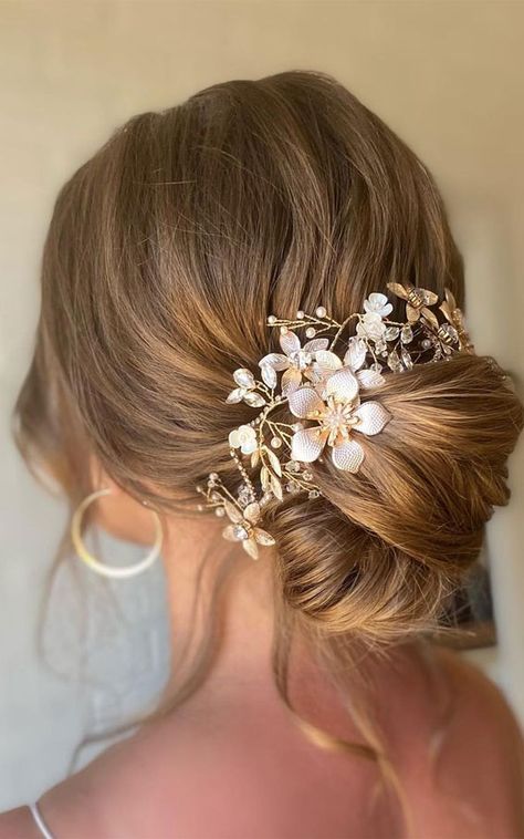 Bun With Gold Accessories, Banquette Dresses, Prom Hair Updo With Clip, Low Bun Wedding Hair Flowers, Low Bun Wedding Hair With Flowers, Loose Elegant Updo, Low Updo Wedding Hair With Flowers, Low Bun With Flowers, Hairstyles Low Bun