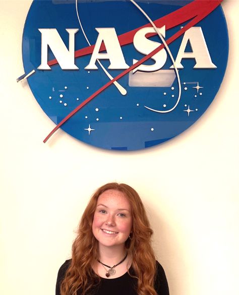 Image Description: Maddie Rozmajzl standing against white wall with NASA meatball above her University Of South Dakota, Science Engineering, Math Stem, Workforce Development, Summer Internship, Biomedical Engineering, Academic Calendar, Student Resources, School Admissions