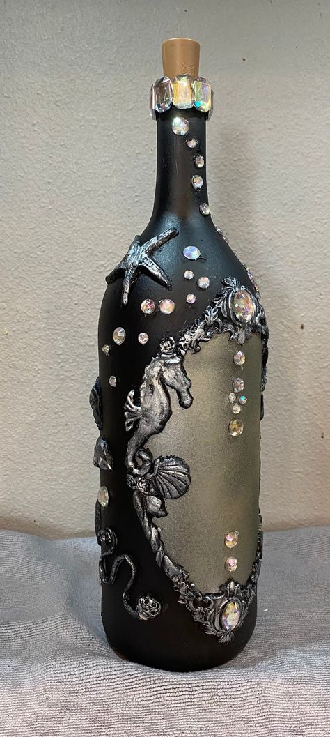 Dramatic black and silver, sea themed fairy lighted wine bottle, it's embellished with faux rhinestones which adds glitter. It is a fun piece great for any occasion or decor. A great gift for birthdays, anniversaries, house warmings, Christmas, weddings, showers, or just to enjoy as a decoration in your own home.  On of a kind, I try not to make the same item twice. Nightmare Before Christmas Wine Bottles, Decorating Glass Bottles Diy, Mixed Media Bottles, Decorating Liquor Bottles, Diy Alcohol Bottles Crafts, Recycle Wine Bottles, Empty Wine Bottle Crafts, Bejeweled Bottles, Wine Bottle Fairy Lights