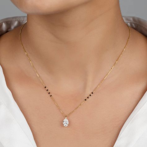 Unveil your unique style with the Nimi Mangalsutra, where classic tradition meets sleek modernity. This standout piece features a stunning vertically-set oval lab-grown diamond, available in various sizes and grades, showcased within a sleek bail pendant for easy customization. Forged from premium 18K solid gold—choose from yellow, white, or rose—this design is accentuated with four distinctive black beads on either side of the chain, each symbolizing strength and direction. The Nimi Mangalsutra New Latest Mangalsutra Design, Elegant Mangalsutra Designs, Latest Mangalsutra Design 2024, Black Beads Designs Latest, Mangal Sutra Designs Gold Modern, Minimal Mangalsutra Designs, Diamond Mangalsutra Designs Unique, Gold Mangalsutra Designs Latest Unique, Thaali Chain Designs Gold