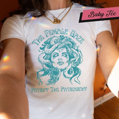 In stock. Going soon. The Female Gaze Baby Tee, Petrify the Patriarchy Shirt, Feminist Shirt , Activism, Women's Rights, Girls Power, Gift For Women Gift For Her only at £16.00.. #TheFemaleGaze #GiftForHer #SpookyLiberal #PetrifyPatriarchy #GothFeminist #FemmeBabyTee #FeministTop #ActivismShirt #ShirtGift #ReproductiveRights Feminist Tops, The Female Gaze, Female Gaze, Girls Power, The Patriarchy, Feminist Shirt, Women's Rights, Womens Rights, Kids Tops