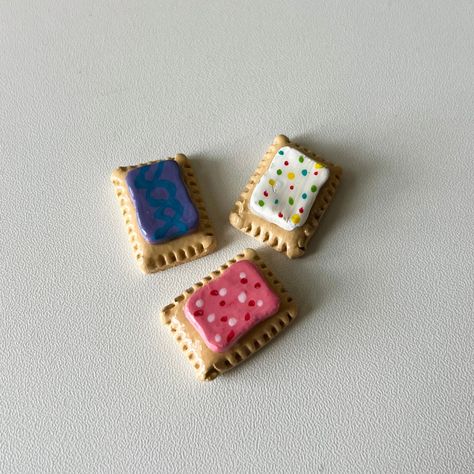 Looking for a little fun and whimsy to brighten up your kitchen? These Handmade Pop Tart Magnets are here to sprinkle some joy on your fridge or any magnetic surface! Each magnet is lovingly handcrafted with air-dry clay, painted with vibrant acrylic colors, and finished with a protective glaze to keep them looking deliciously fresh! No two Pop Tarts are exactly alike, giving you a one-of-a-kind set - Pack of 3!  Great for Pop Tart lovers, fun-loving friends, or anyone who could use a little mor