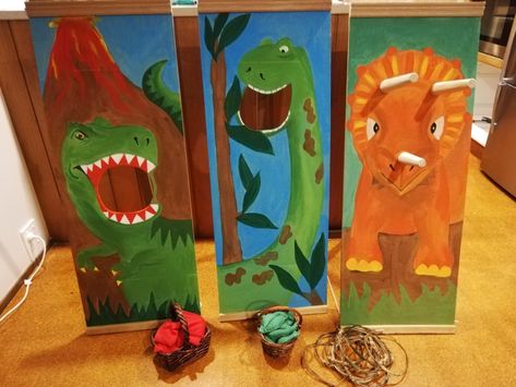 We made these games for our grandsons' birthday party.  Feed T Rex red bean bags, feed Brachiosaurus green leaf shaped bean bags and Triceratops ring toss.  They are painted on particle board with a timber stand.  I made the rings with small branches and the horns are sofa legs from the hardware store.  I made the bean bags and filled them with rice. Feed The Dinosaur, Feed The T Rex Game, Dino Party Games Activities, Dinosaur Summer Camp Activities, Feed The Trex Game Dinosaur Party, Dinosaur Scene Art, Dinosaur Party Games, Dinosaur Activities, Dinosaur Theme