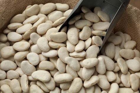 A close-up of dry lima beans in a burlap sack with a scoop. Lima Beans In Crockpot, Cooking Lima Beans, Lima Bean Soup, Lima Bean Recipes, Dry Beans Recipe, Scarlet Runner Beans, Butter Beans Recipe, Good Source Of Protein, Beans In Crockpot