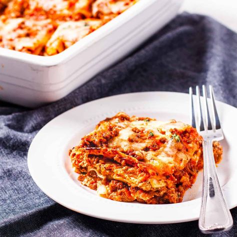 Side angle view showing a serving of lasagna alongside the lasagna dish. Lasagna With Bechamel Sauce, Leftover Lasagna, Homemade Lasagna Recipes, Laura In The Kitchen, Homemade Meat Sauce, Lazy Lasagna, Easy Lasagna Recipe, Queso Cheddar, Homemade Lasagna