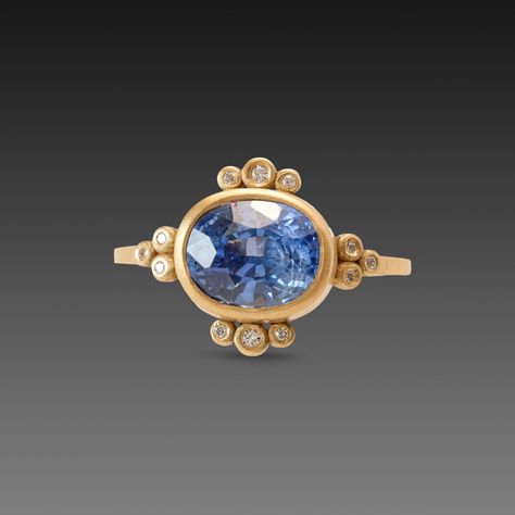 This stunning ring features a vibrant oval shaped blue sapphire, framed by twelve sparkling white diamonds. This very special gem is set in 18k yellow gold on a 1.5mm band. The center stone measures 7mm x 9mm, and weighs 3.59 ct. Matte finish. Drop Painting, Sapphire Ring Designs, Round Painting, Oval Sapphire Ring, Bezel Set Engagement Ring, Cute Engagement Rings, Dragonfly Necklace, Ring With Diamond, White Diamonds