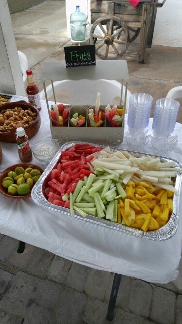 Fruit Table Ideas Birthday Mexican, Fruit Table For Party, Diy Fruit Stand For Party, Mexican Fruit Bar Ideas Parties, Fruit Bar Party, Birthday Party Food Mexican, Mexican Fruit Tray Ideas For Party, Mexican Wedding Fruit Table, Mexican Fruit Tray