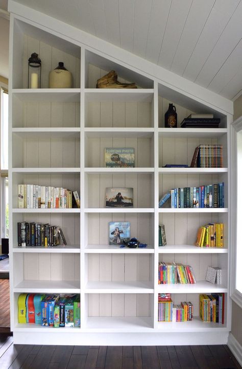 One of a Kind Custom white open shelving unit, built to fit in angled ceiling Shelves On Angled Wall, Bookshelf Angled Ceiling, Built In Shelves On Slanted Wall, Built In Bookshelf Sloped Ceiling, Angled Ceiling Shelves, Slanted Wall Library, Angled Wall Built In, Built In Bookshelves Sloped Ceiling, Built In Bookcase Slanted Ceiling