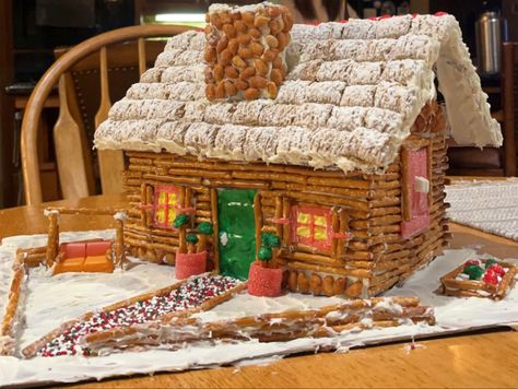 This is a homemade gingerbread house made with pretzels and frosting, starbursts, frosted mini wheats and peanuts Gingerbread Trap House, Gingerbread House Pretzels, Cereal Gingerbread House, Barn Gingerbread House, Fun Gingerbread House Ideas, Gingerbread House Funny, Pretzel Gingerbread House, Gingerbread House Competition, Unique Gingerbread House Ideas