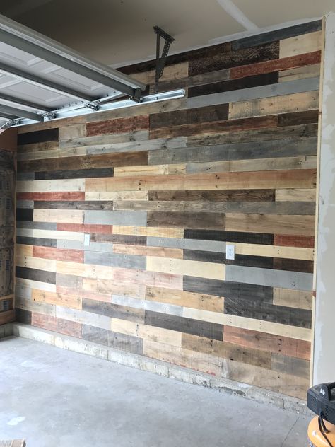 Pallet wall garage. Pallet Garage Wall, Pallet Board Wall, Pallet Wall Basement, Garage Walls Covering Ideas, Pallet Wall With Lights Behind It, Wall Pallet Exercise, Pallet Wood Garage Walls, Pallet Wall Ideas, Wood Garden Beds