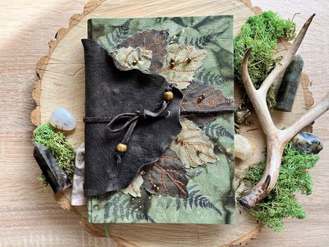 This gorgeous Botanical floral forest herb journal is an example of what you can get with this notebook. Cover design and content may vary slightly. The hardcover Cottagecore Leaf Journal is covered in hand-dyed fabric and decorated with fabric leaves and glass beads. The second layer of the cover is soft dark brown leather. The spine of the book is embroidered with thick threads and decorated with bronze decor. The Green Witch Book is closed with a leather cord, which can be wrapped around the Green Witch Book, Book Cottagecore, Herb Journal, Leaf Journal, Fairy Junk Journal, Nature Notebook, Fairy Journal, Handmade Sheet, Bronze Decor