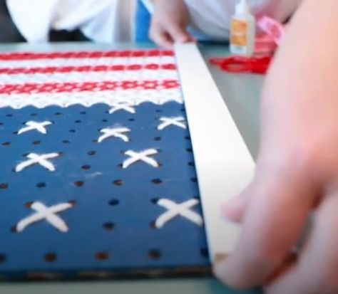 Discover how to make stunning cross stitch wall decor with pegboard by checking out this clever project, which revolves around recreating the iconic US flag. Flag Window Pane, Plastic Canvas Flags, American Flag Cross Stitch Pattern, Usa Flag Cross Stitch Pattern, Flag Wall Hanging, Fireplace Wall, Peg Board, Patriotic Decorations, Easy Step