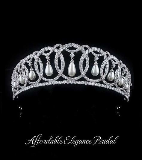 Grand Duchess Vladimir Royal Replica Tiara Crown This regal tiara is a replica of the tiara created for Grand Duchess Maria Pavlovna of Russia as pictured on Queen Elizabeth. This fabulous 2" tall silver platinum plated headpiece features a unique design of interlocking circles accented with hanging pearls. The AAA quality cz crystals and luminous shell pearls will provide sparkle from every angle! This crown will ensure head-turning elegance on your big day. Color: Silver. Style: hp223QE. Size: About 2 " tall at the center peak. An unforgettable crown for your wedding day! Please allow 2-3 weeks for delivery. Shipping Policy . Return Policy. Vladimir Tiara, Grand Duchess Vladimir, Diamond Tiara Wedding, Winter Wedding Accessories, Maria Pavlovna, Gold Bridesmaid Jewelry, Beaded Wedding Veils, Queens Tiaras, Cars Rolls Royce