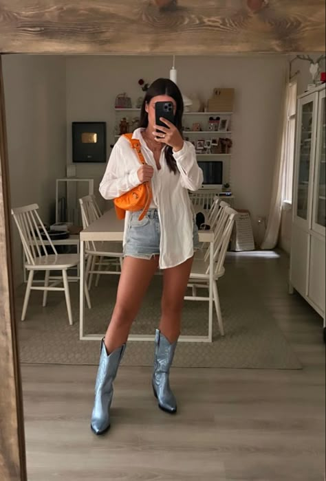 Denim shorts with white top orange bag purse and blue cowboy boots everyday outfit combinatoon mirror selfie Jeans Shorts And Cowboy Boots, Cowgirl Boots Outfit Street Style, Cowboy Boots Biker Shorts Outfit, Casual Western Boots Outfit, Calf Boots Outfit Summer, Baseball Game Outfit Cowboy Boots, Cowgirl Boots Street Style, Colored Cowboy Boots Outfit, Denim Shorts Cowboy Boots