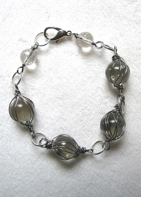 Vintage clear marbles are wrapped in stainless steel wire. Sure to compliment any outfit! Clear quartz accents at the ends of the bracelet. 8" long. Metal lobster claw clasp. Marble Ideas Crafts, Diy Bracelets And Necklaces, Stainless Steel Wire Jewelry, Steel Wire Jewelry, Wired Necklaces, Metal Wire Jewelry, Marble Crafts, Wired Bracelet, Marble Bracelet