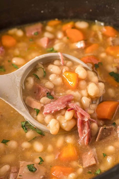 Learn how to make a delicious and hearty crockpot ham and bean soup with this easy recipe. You'll dive into a bowl of homemade goodness with this perfect comfort food for a cozy night in. An easy slow cooker soup recipe and great use of leftover ham. Slow Cooker Navy Bean Soup, Crockpot Ham Bone Soup, Crock Pot Ham And Bean Soup, Crockpot Bean Soup Recipes, Navy Bean Soup Crockpot, Ham Hocks And Beans In Crockpot, Crockpot Ham And Bean Soup, Bean Soup Crockpot, Ham Bean Soup