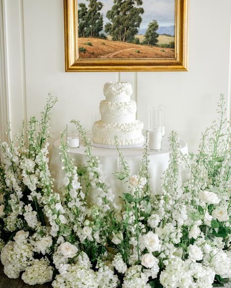 all white cake table surrounded by lush greenery and ivory florals Cake Table Florals, Cake Table Flowers, Wedding Cake Table Decor, Cake With White Flowers, Cake Florals, Wedding Cake Table Decorations, Table Florals, Wedding Cake Display, Sweetheart Table Wedding