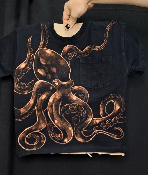 Create a unique look with this fearless kid's bleach hand painted kraken t-shirt.#handmadeclothing #customshirts #bleachshirts #craftideas #DIYfashion Cool Bleach Shirt Designs Grunge, Tshirt Bleaching Ideas, Bleach T Shirt Art, Bleach Painting Clothes Ideas, Painted Tshirts Diy Ideas, Bleached Tshirt Ideas, Bleach Tshirt Designs, Bleach Art Clothes, Diy Clothes Bleach