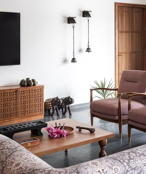 Completing the living room is the media cabinet made in teak. Jaali details adorn the cabinet shutters mapping the chequered pattern similar to the ceiling. We sourced various antiques from table decor to wall decor to infuse life and a story within this home 🥰 .  #studioipsa #livingroom #livingroomdesign #livingroomdecor #livingroominspiration #mediaunit #tvunit #tvconsole #tvconsoledesign #interiordesign #interiorstyling #interiordesigninspiration #interiorideas #mediaunit #jaalipatteren Chettinad Living Room, Living Room Wallpaper Indian, Indian House Living Room, Minimal Contemporary Living Room, Modern Antique Living Room, Earthy Interior, Indian Living Room Decor, Indian Living Room Design, Antique Living Room