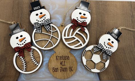 "These adorable snowmen make the perfect gift. This listing is for a single ornament. Choose from Baseball, Soccer, Volleyball, Bocce, Pickleball and Basketball. Great for all the athletes and coaches :).   Each measures approximately 4.5\" x 2.5\". and are made from 3 layers. **This listing is for a single ornament. Personalized and includes 2024 engraved on hat. Personalization on back is laser engraved. Add Name, number, club/school name or a personal message ~ or any combo. The personalization you request will be scaled to fit on the back, so the more info you include the smaller the font will be." Wood Engraved Christmas Gifts, Laser Engraved Ornaments, Laser Engraving Ideas Gifts, Sport Ornaments Diy, Cricut Baseball Ornaments, Layered Wood Christmas Ornaments, Laser Ornaments, Laser Engraving Ideas, Personalized Coach Gifts