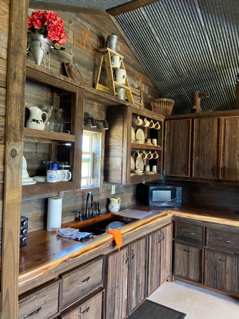 Reclaimed barnwood facing the cabinets and drawers, reclaimed fence boards on the walls, reclaimed tin ceiling, live edge ceder counter. Barnwood And Tin Walls, Barnwood Cabinets, Barnwood Kitchen Cabinets, Cabin Cabinets, Barn Tin Wall, Tin Ceiling Kitchen, Tiny Cabin Kitchen, Teal Kitchen Walls, Barn Wood Cabinets