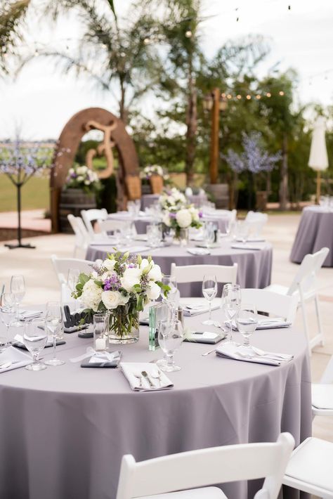 Wedding table centerpieces, flowers with gray tablecloths, Hanford Ranch Winery, Galt, CA Lavender Table Cloth Wedding, Lavender Tablecloth Wedding, Wedding Table Settings Lavender, Lavender And Sage Wedding Table Settings, Purple And Lilac Table Setting, Purple Table Cloth Wedding, Gray Tablecloth Wedding, Light Purple Wedding Table Decor, Light Purple Table Decorations