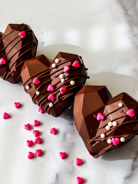 On Valentine’s Day create a special moment by making these Heart-Shaped Hot Cocoa Bombs. Melted milk chocolate is formed into heart-shaped bombs and filled with surprises like marshmallows, and sprinkles. #hotcocoabombsrecipe #hotcocoabombs #heartshapedhotcocoabombs #valentinesdayrecipes Week Night Meals, Almond Crunch, Food Gift Ideas, Hot Chocolate Bomb, Homemade Food Gifts, Chocolate Ideas, Chocolate Company, Mini Cakes Birthday, Heart Shaped Cakes