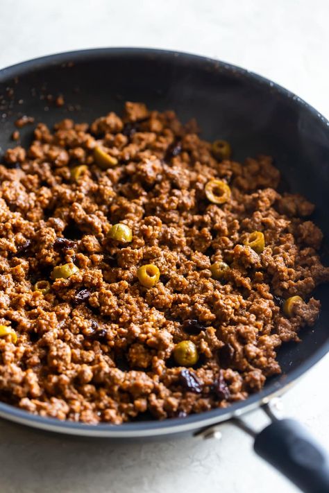 Cuban-Style Beef Picadillo Recipe. A simple and flavorful ground beef dish made Cuban-style with tomato sauce, spices, olives, and raisins. Perfect weeknight meal! Picadillo Recipe With Raisins, Picadillo With Raisins, Cuban Picadillo Authentic, Cuban Picadillo, Beef Picadillo, Beef Olives, Sweet Plantains, Picadillo Recipe, Beef Tomato