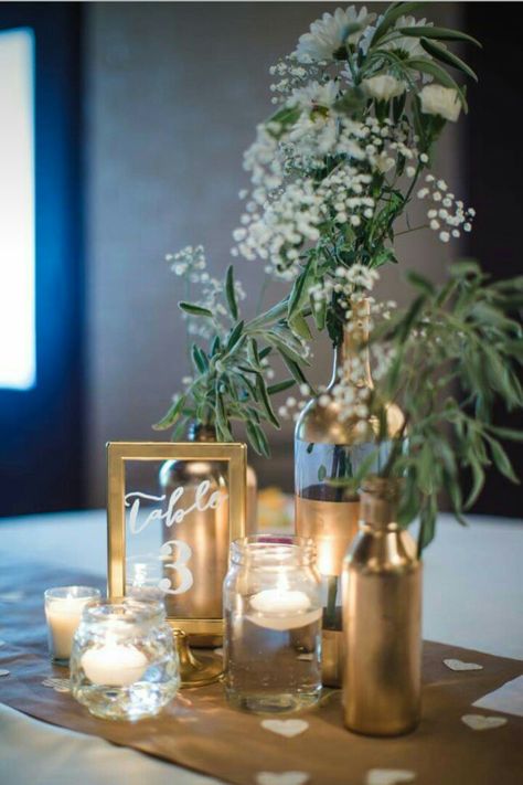 Gold centerpieces Good Centerpieces, Black Gold And Green Centerpiece, Wine Bottle Wedding Decor Centerpieces, Simple Banquet Centerpieces, Wine Bottle Party Decorations, Green Gold And White Centerpieces, Elegant Gala Centerpieces, Greenery Ring Centerpiece, Gold And Black Table Centerpieces