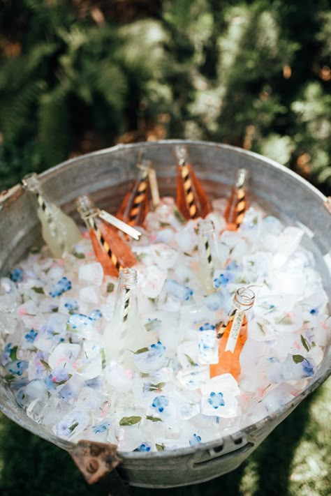 Lend a touch of whimsy to your drink cooler with floral ice cubes. So easy to DIY, but they make a huge impact. #diy #partyideas #partydrinks #babyshower #birthdayparty Floral Ice Cubes Champagne, Blue Flower Ice Cubes, Drink Coolers For Parties, Ice Cooler Ideas, Graduation Brunch Ideas, Floral Grad Party, Bee Party Theme, Iced Flowers, Floral Ice Bucket