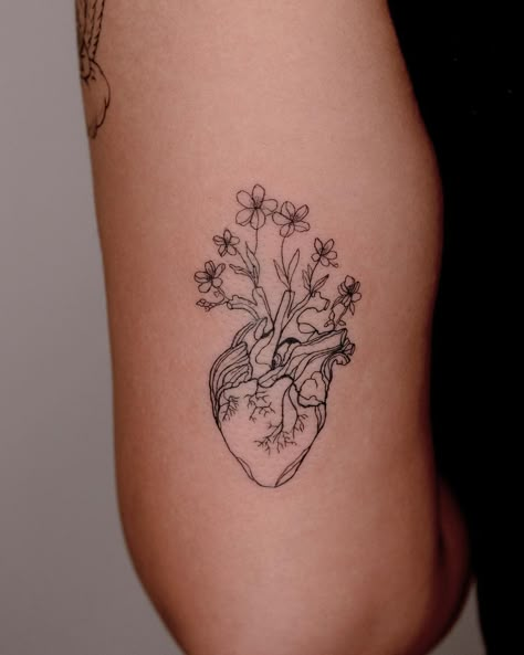 heart and flowers tattoo Fine Line Anatomical Heart Tattoo With Flowers, Heart Into Flower Tattoo, Heart Arm Tattoos For Women, Red Real Heart Tattoo, Grow Together Tattoo, Upper Arm Heart Tattoo, Realistic Heart With Flowers Tattoo, Flower Hearts Tattoo, Realistic Heart Tattoo Flowers