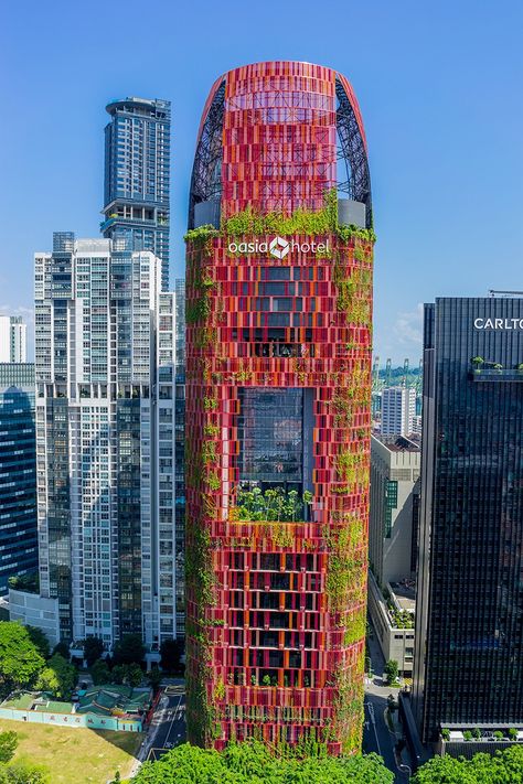 the verdant hotel tower is clad in a mosaic of red aluminum mesh paneling that has allowed the integration of 21 species of creepers, plants and flowers. Creepers Plants, Green Tower, Green Facade, Skyscraper Architecture, Interesting Buildings, Green Architecture, Amazing Buildings, Unique Buildings, Unique Architecture