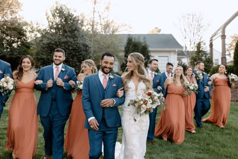 Navy groomsmen suits and terracotta bridesmaid dresses group bridal party photo Terracotta Groomsmen Attire, Navy Blue And Terracotta Wedding, Navy Groomsmen Suits, Groomsmen Colours, Navy Groomsmen, Burnt Orange Bridesmaid Dresses, Navy Suit Wedding, Bridal Parties Colors, Orange Wedding Colors