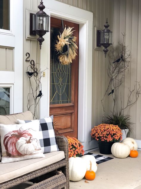 Orange Mums, white pumpkins with straw wreath, tree branches with black crows and buffalo check pillow and pumpkin pillow on bench. Sophisticated Halloween, Porch Fall Decor, Fall Front Door Decor, Halloween Decor Diy, Casa Halloween, Halloween Front Porch Decor, Fall Front Porch Decor, Halloween Front Porch, Fall Front Door