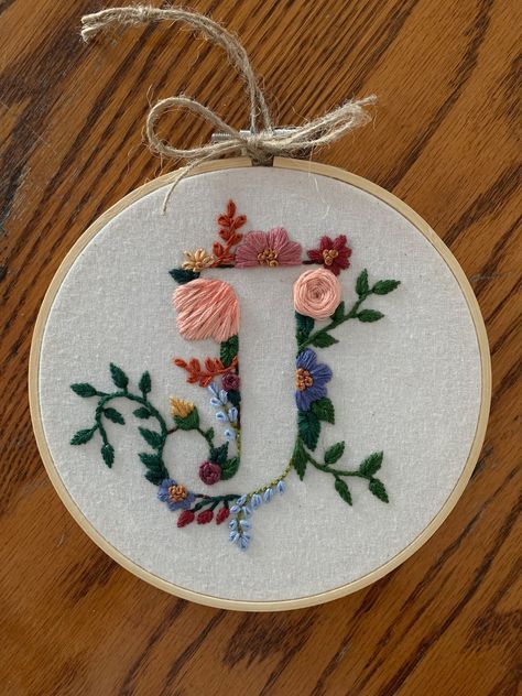 Custom made, hand embroidered floral letter. Made with 100% cotton fabric as well as DMC 100% cotton thread. The hoop used is 5 inches in diameter, natural wood. Completed with paper backing to protect stitching.  Can create any letter. The colour schemes to choose from will represent the majority of the colours used for the flowers with some variation used for smaller flowers, stems and leaves.  This will make a perfect gift for anyone. Lovely for kids rooms and nurseries, birthday and shower g Flower Letters Embroidery, F Embroidery Letter, Embroidered Initials Hand Embroidery, Hand Embroidered Initials, Embroider Gift Ideas, A Letter Embroidery Design, Embroidered Letters Floral, B Embroidery Letter, K Embroidery Letter