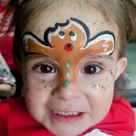 Face painting a gingerbread man Holiday Face Painting For Kids, Gingerbread Man Face Paint, New Years Face Paint, Holiday Face Painting, Easy Christmas Face Paint, Christmas Facepainting Kids Easy, Simple Christmas Face Paint, Gingerbread Faces Painting, Easy Christmas Face Painting Ideas