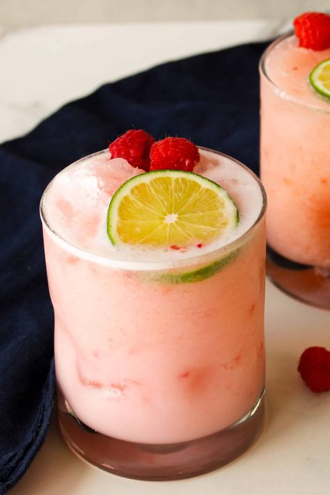 Pale pink raspberry coconut margaritas in rocks glasses on a marble counter. Raspberry Coconut Margarita, Lemonchello Drinks Cocktails, Lemonchello Drinks, Boozy Punch, Coconut Cocktails, Ovulatory Phase, Raspberry Drink, Raspberry Cocktail, Peach Margarita