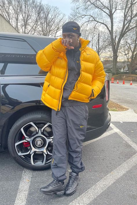 Lil Yachty is wearing a yellow Nike x Drake NOCTA Puffer Jacket, a black Nike x Drake NOCTA Track Jacket, and black Nike Air Max 95 Lux Supreme. Links to his featured outfit are available! Yellow Puffer Jacket Outfit, Nike Air Max 95 Outfit, Puffer Jacket Nike, Yellow Jacket Outfit, Gold Puffer Jacket, Streetwear Outfit Men, Air Max Outfit, Track Black, Black Nike Air Max