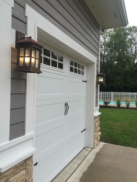 CHI carriage house garage door installed by Rolling & Sliding Doors of Dayton Garage With White Doors, Townhouse Updates, Garage Trim, Garage Door Trim, Garage Door Lights, Barn Style Garage, White Garage Doors, Carriage Style Garage Doors, Carriage House Garage Doors