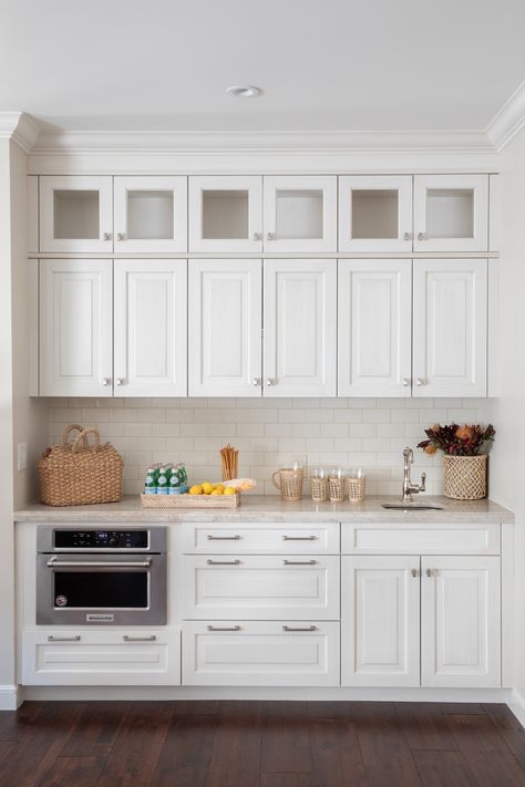 Traditional, all-white butler's pantry with clean white tile backsplash, silver finishings, and a marvelous granite countertop. A clean and simple storage design brought to life with some coastal new england touches, creating the perfect place in your home to display these gorgeous summer pieces. #coastal#newenglandcoastal#newnenglandsummer#storage#whitekitchen#rattan#Instagram#pinterest#aesthetic#homedecore#design#Hillsboroughg#architecture#photography#art Photo By Vivian Johnson Photography White Coastal House, Blue And White Coastal, Coastal New England, White Tile Backsplash, Summer Pieces, Granite Countertop, Coastal House, Designer Interior, Butler's Pantry