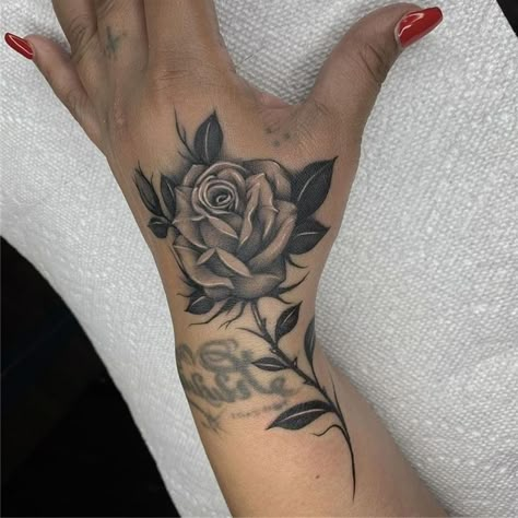 Rose Tattoo On Side Of Hand, Butterfly And Rose Hand Tattoo, Hand Name Tattoos For Women, Inner Wrist Tattoos For Women Unique, Rose Stem Hand Tattoo, Rose Hand Tattoo Woman, Black Rose Hand Tattoo For Women, Shoulder Rose Tattoo, Black Rose Wrist Tattoos For Women