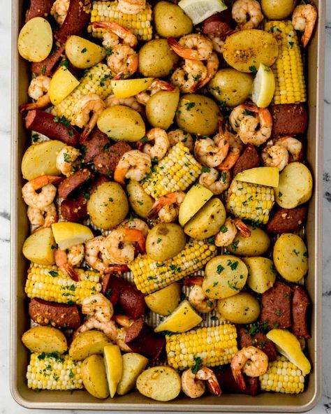 Make this simple Shrimp Boil in Oven in minutes with raw shrimp, baby potatoes, andouille sausage, fresh sweet corn, garlic, butter, and seasoning. It's the perfect sheet pan meal to enjoy anytime. simplylakita.com #shrimpboil Shrimp Boil In Oven, Seafood Stuffing, Sheet Pan Shrimp Boil, Pan Shrimp Boil, Corn Bake, Shrimp Potatoes, Corn Butter, Sheet Pan Shrimp, Raw Shrimp